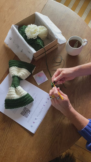 hands making a crocheted Christmas Bow Decoration Green and White